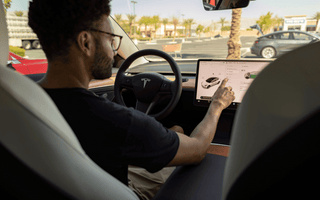 Man customizing his Tesla car with the help of his LCD screen
